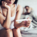 donna con test di gravidanza in mano